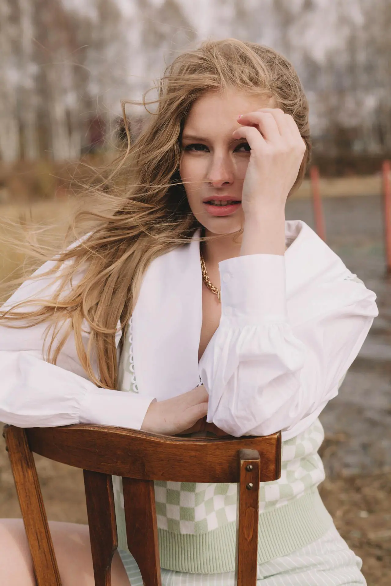 A woman with long blonde hair touches her hair, showing texture improvements from Refresh MedSpa.