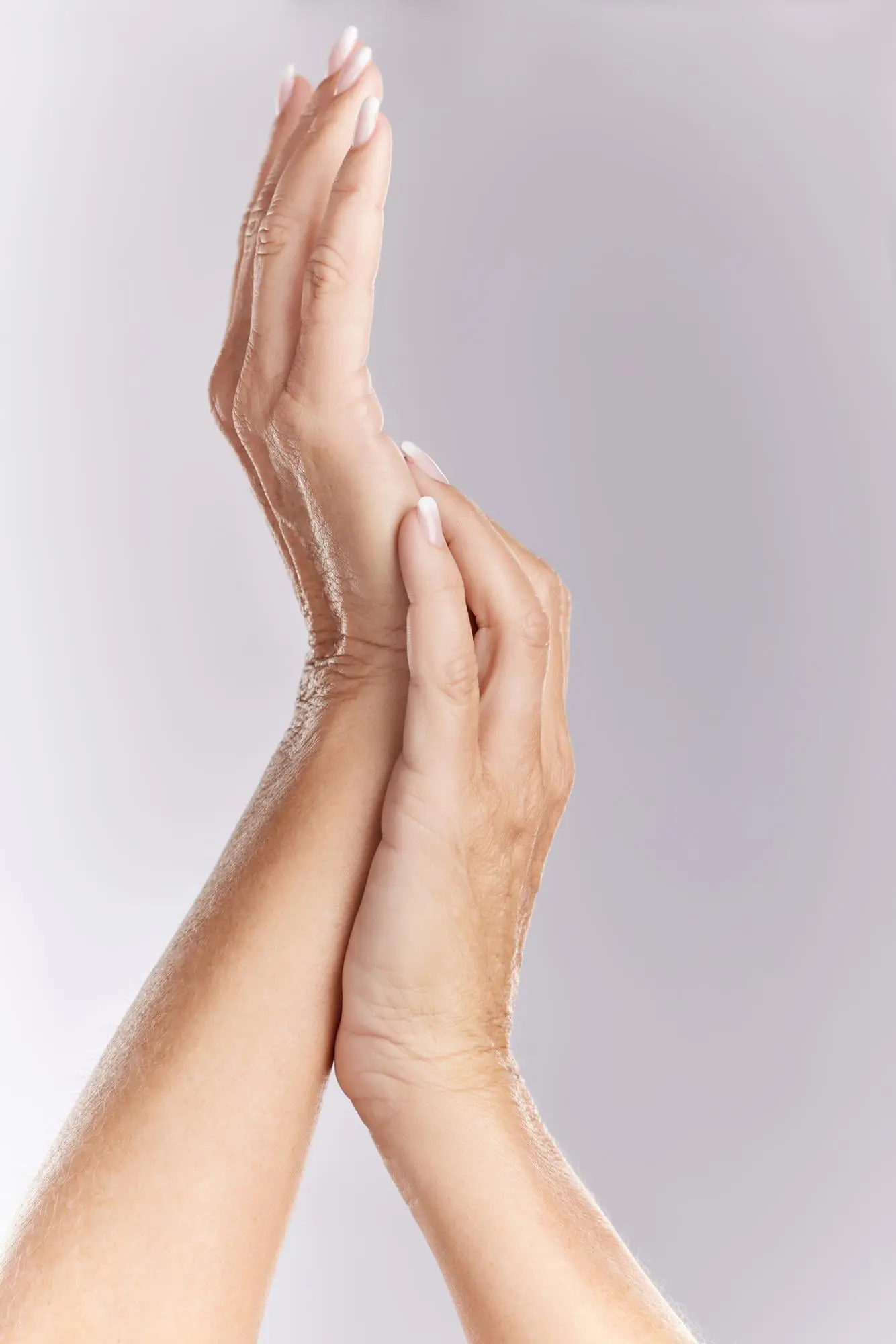 Hands with light skin and manicured nails touch, showing wrinkles and aging; Refresh MedSpa in Cape Coral, FL can help.