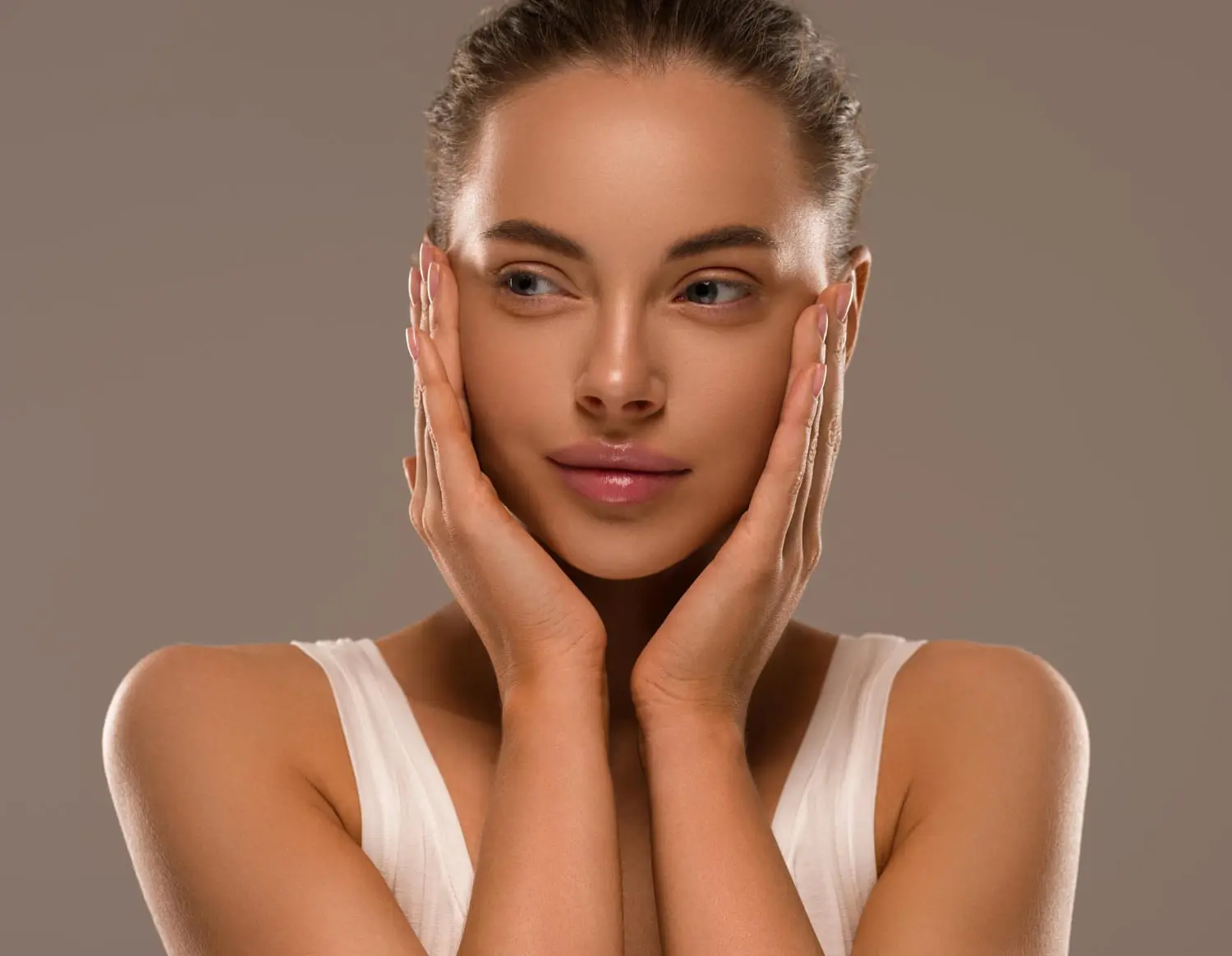 At Refresh MedSpa in Cape Coral, FL, a woman with clear, melasma-free skin gently touches her face in a white tank top.
