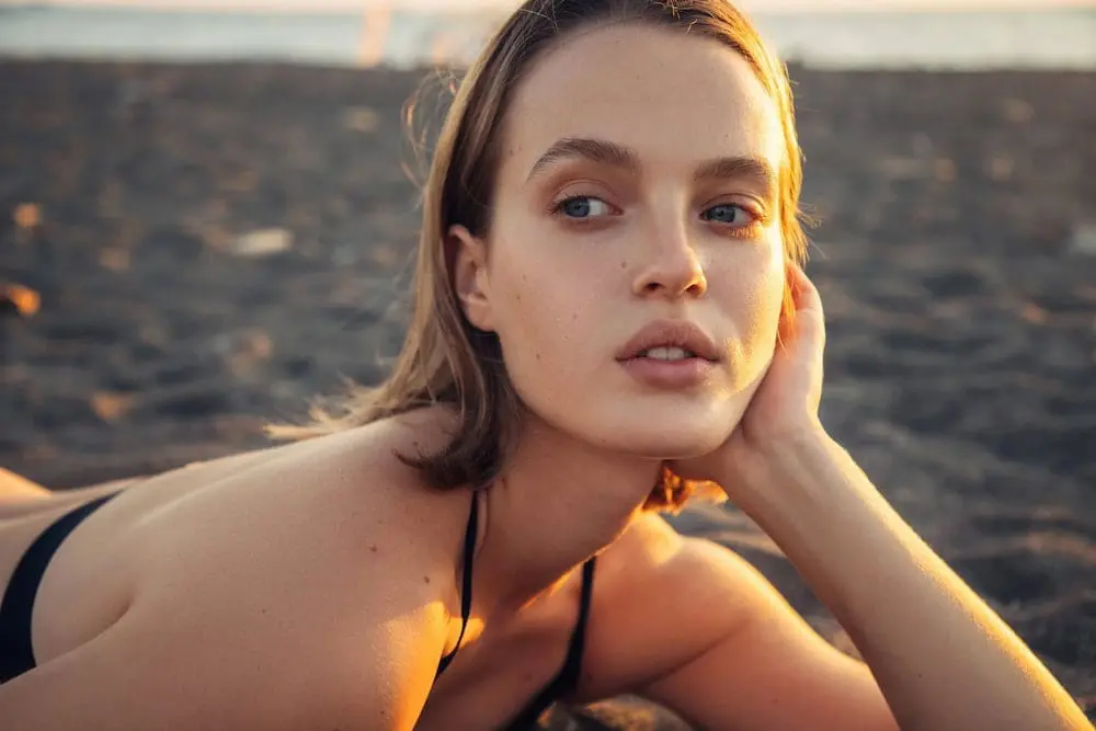 Woman with clear, smooth complexion in golden sunset light, showcasing flawless skin texture and natural beauty achieved through professional acne and acne scar treatments at Refresh MedSpa Cape Coral, FL