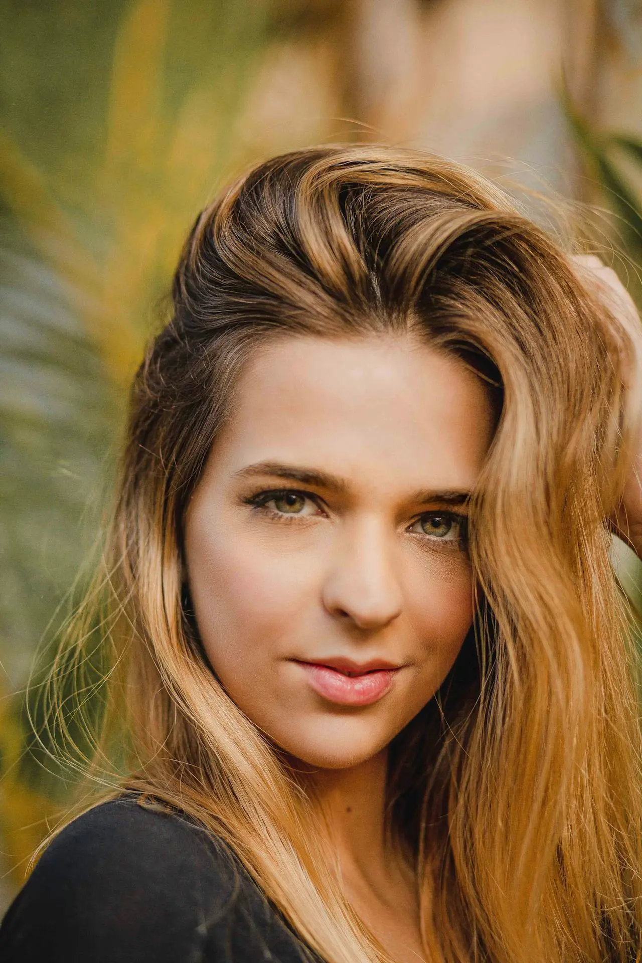 A woman’s smooth complexion—possibly from Xeomin at Refresh MedSpa—contrasts blurred foliage behind.