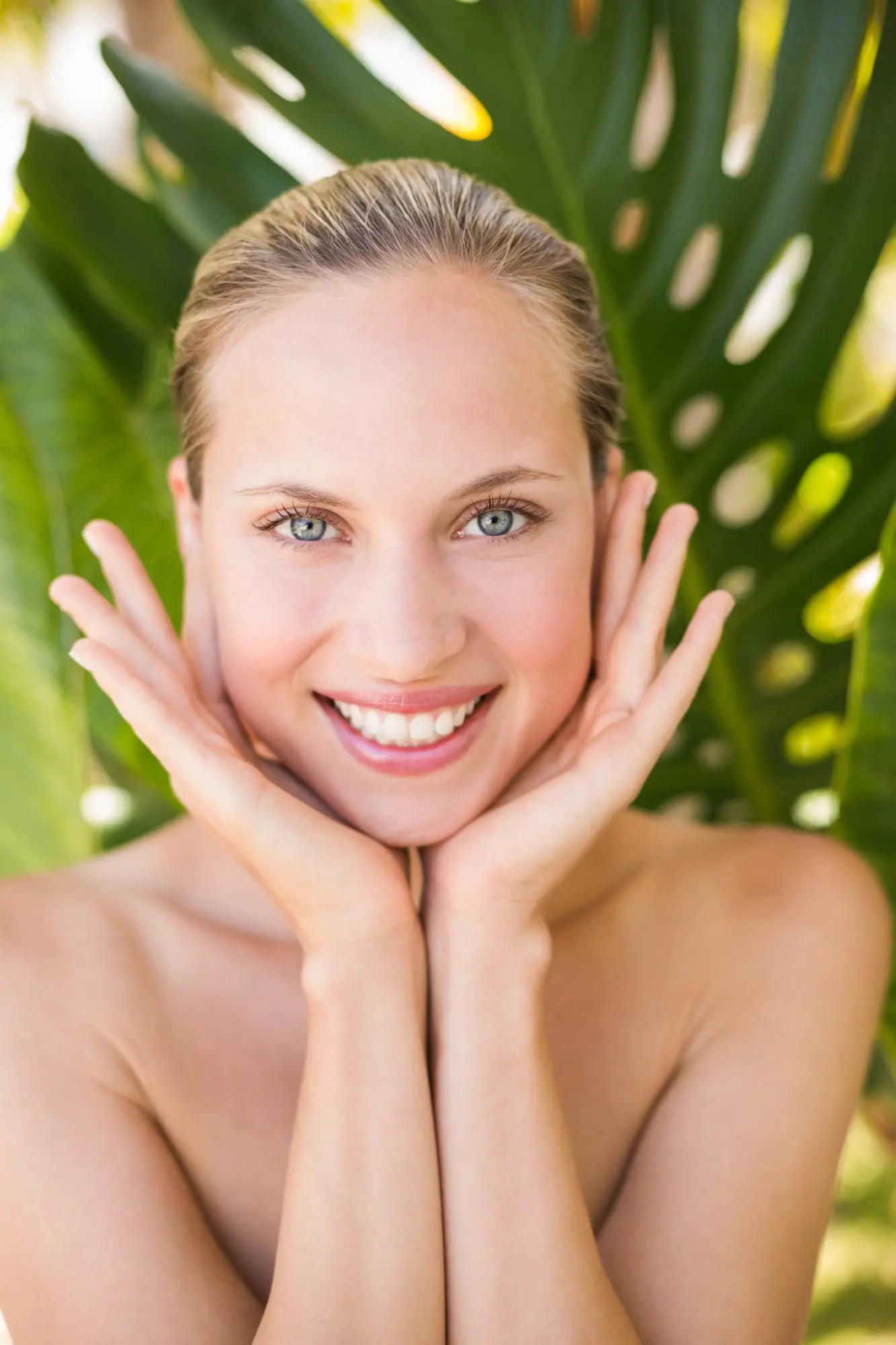 A confident woman smiles at the camera outdoors, showing the post-microneedling glow from Refresh MedSpa.