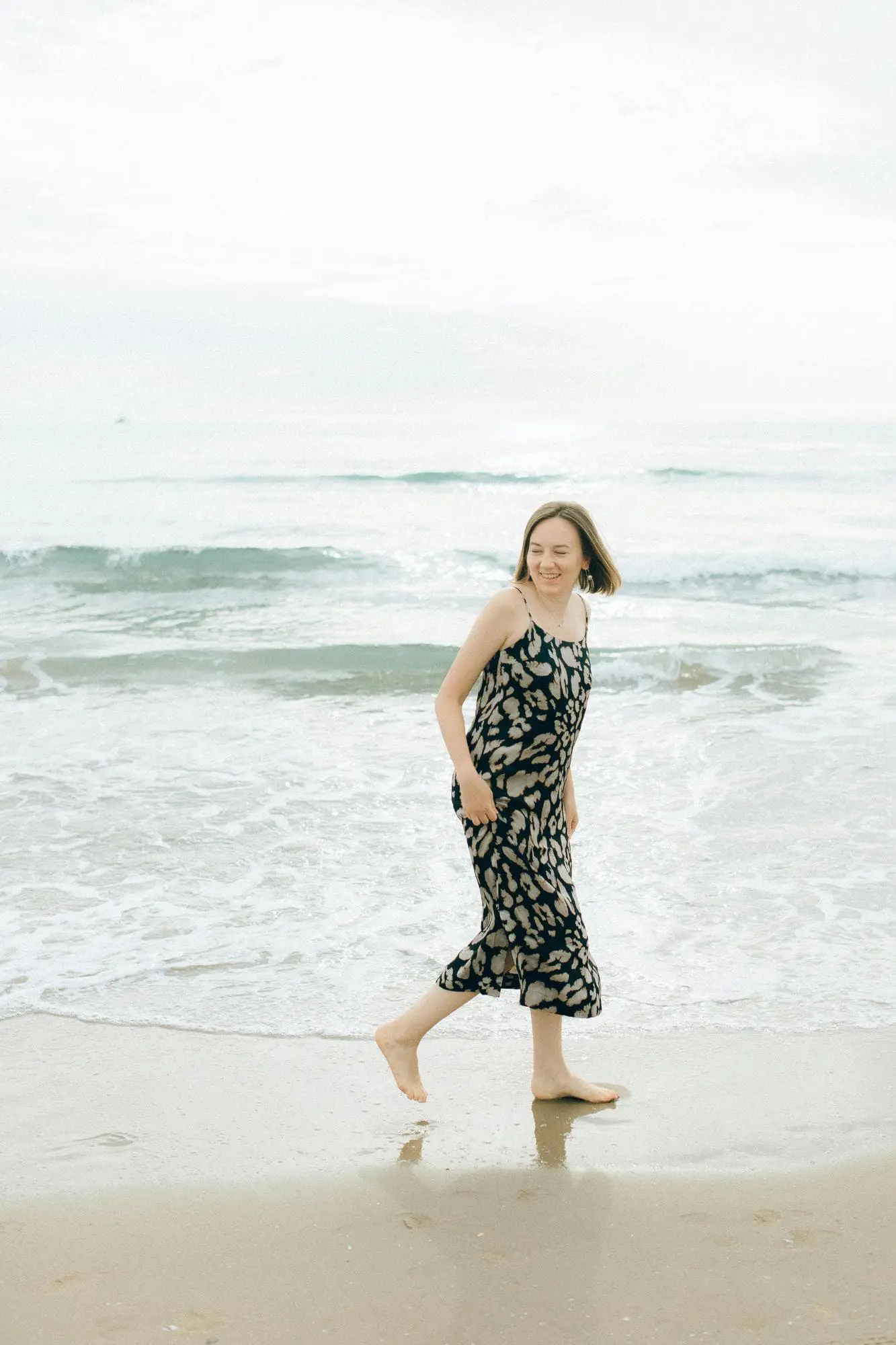 Woman enjoying sunny beach day in orange bikini holding pineapple, representing refreshed and youthful look after Skin Tightening treatment at Refresh MedSpa in Cape Coral, FL serving clients from Fort Myers.