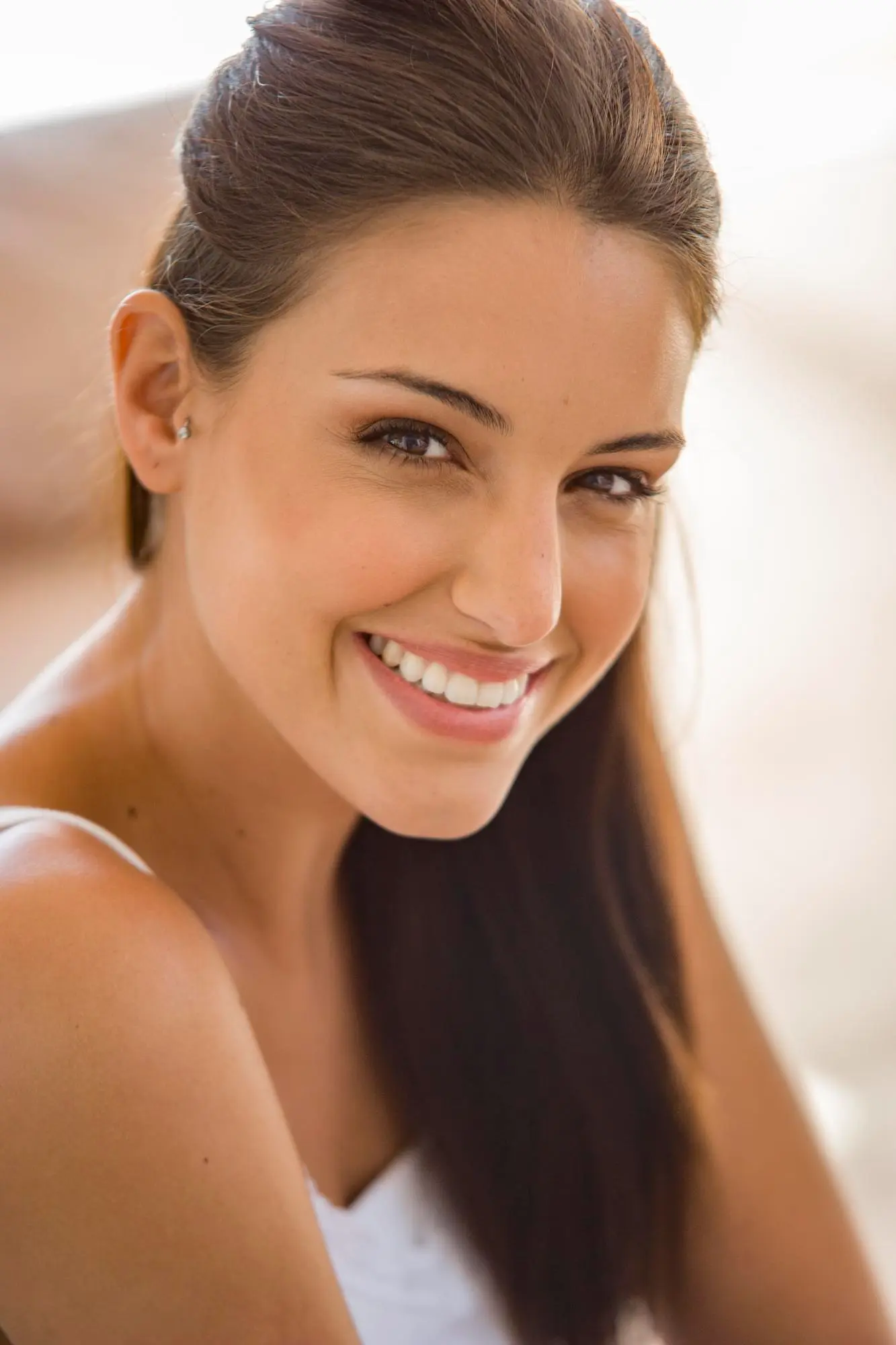 Smiling young woman with long brown hair, radiant skin after BBL Photofacial at Refresh MedSpa in Cape Coral, FL.