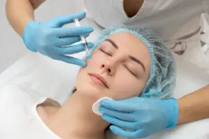 At Refresh MedSpa in Cape Coral, FL, a patient in a hair cap lies with eyes closed as a gloved professional administers Dysport.