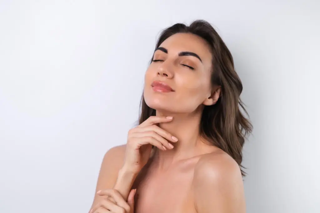 A woman with closed eyes and a slight smile touches her chin, representing Refresh MedSpa in Cape Coral, FL for Restylane results.