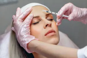 A practitioner performs a cosmetic forehead injection at Refresh MedSpa in Cape Coral, FL, where clients often ask about the duration of Botox for hyperhidrosis.